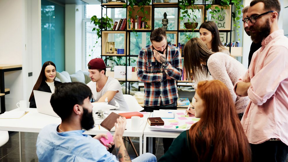 Menschen sitzen um einen Tisch herum und unterhalten sich