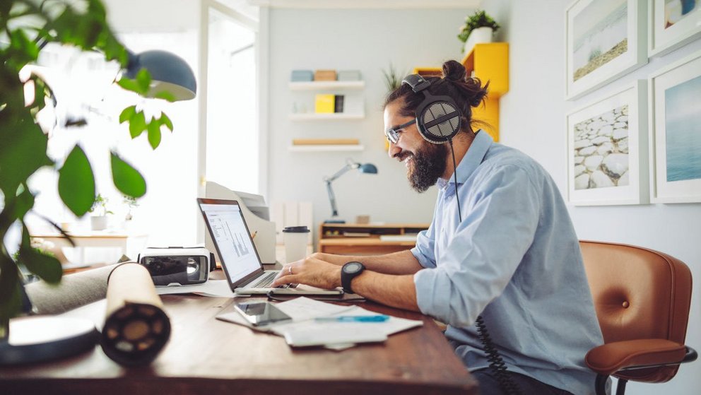 Junger Mann arbeitet zu Hause am Laptop