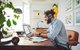 Junger Mann arbeitet zu Hause am Laptop