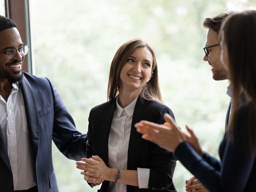 Mehrere Personen stehen zusammen. Sie unterhalten sich und lachen. 