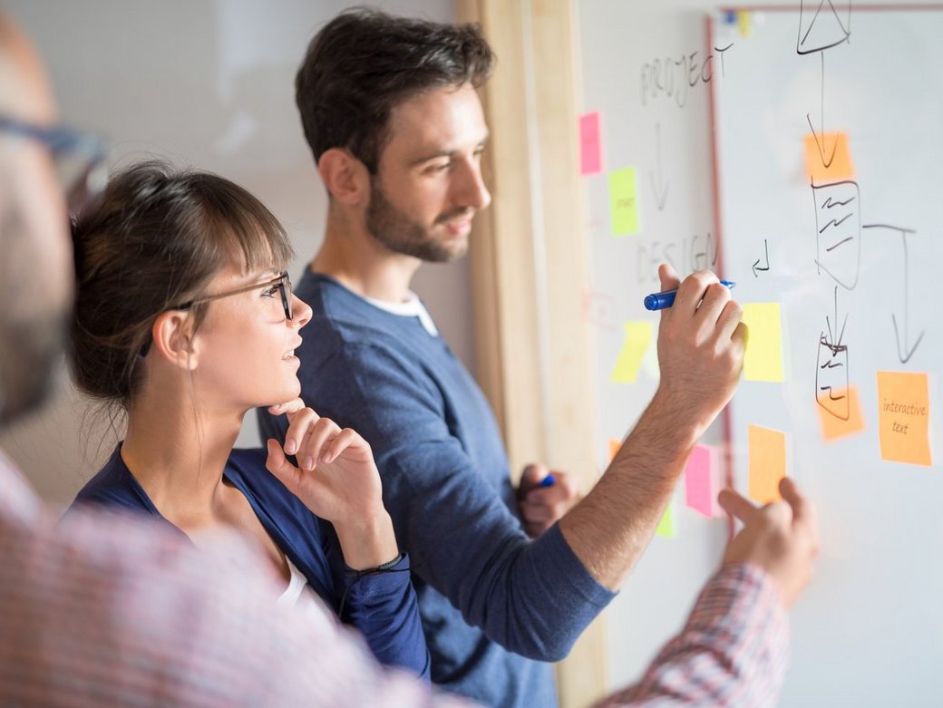 Kreative Geschäftsleute treffen im Büro vor einer Wand mit Post-its